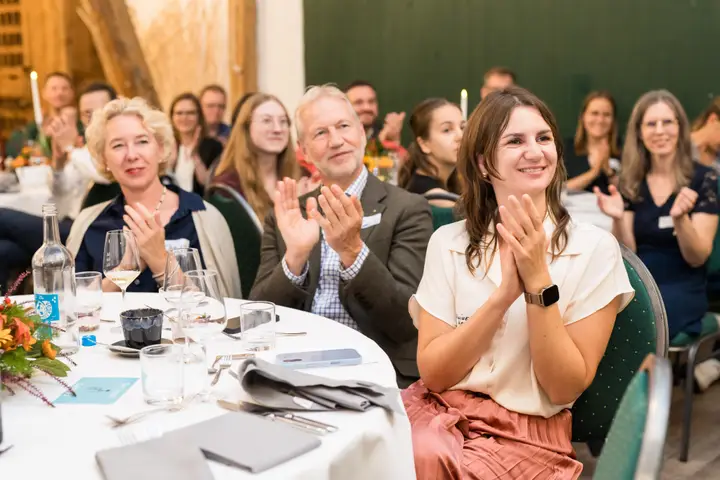 Gäste applaudieren an ihren Tischen